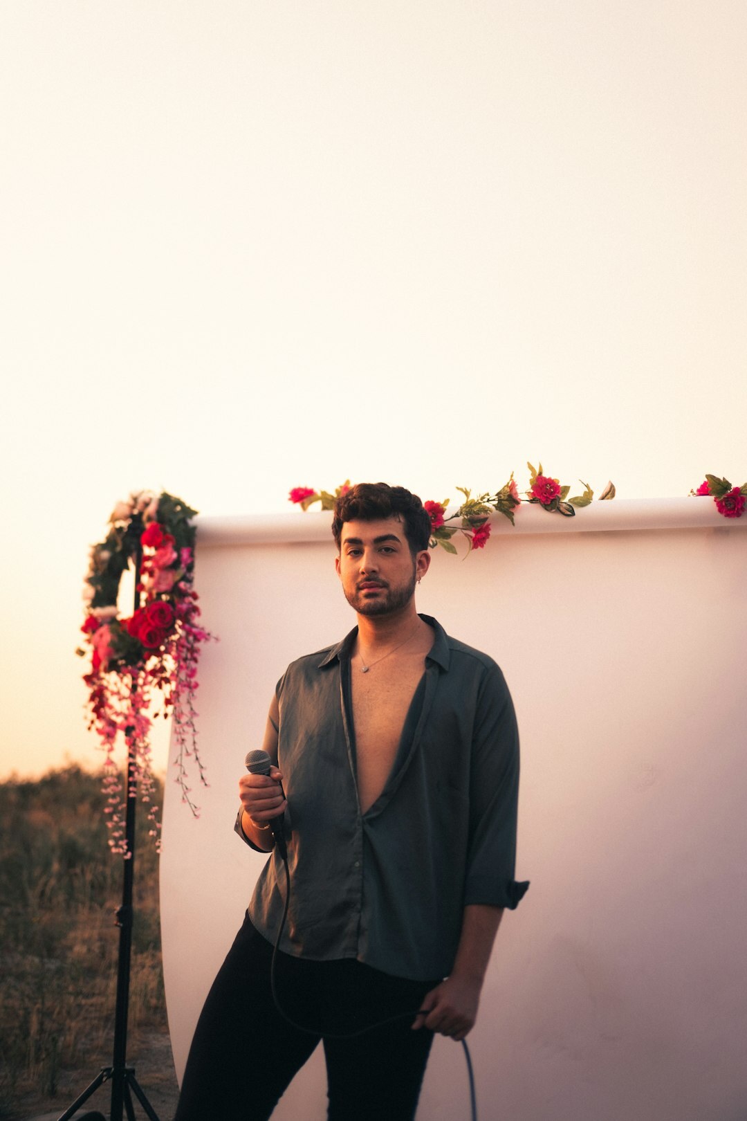 Portrait of a man in a shirt holding a microphone